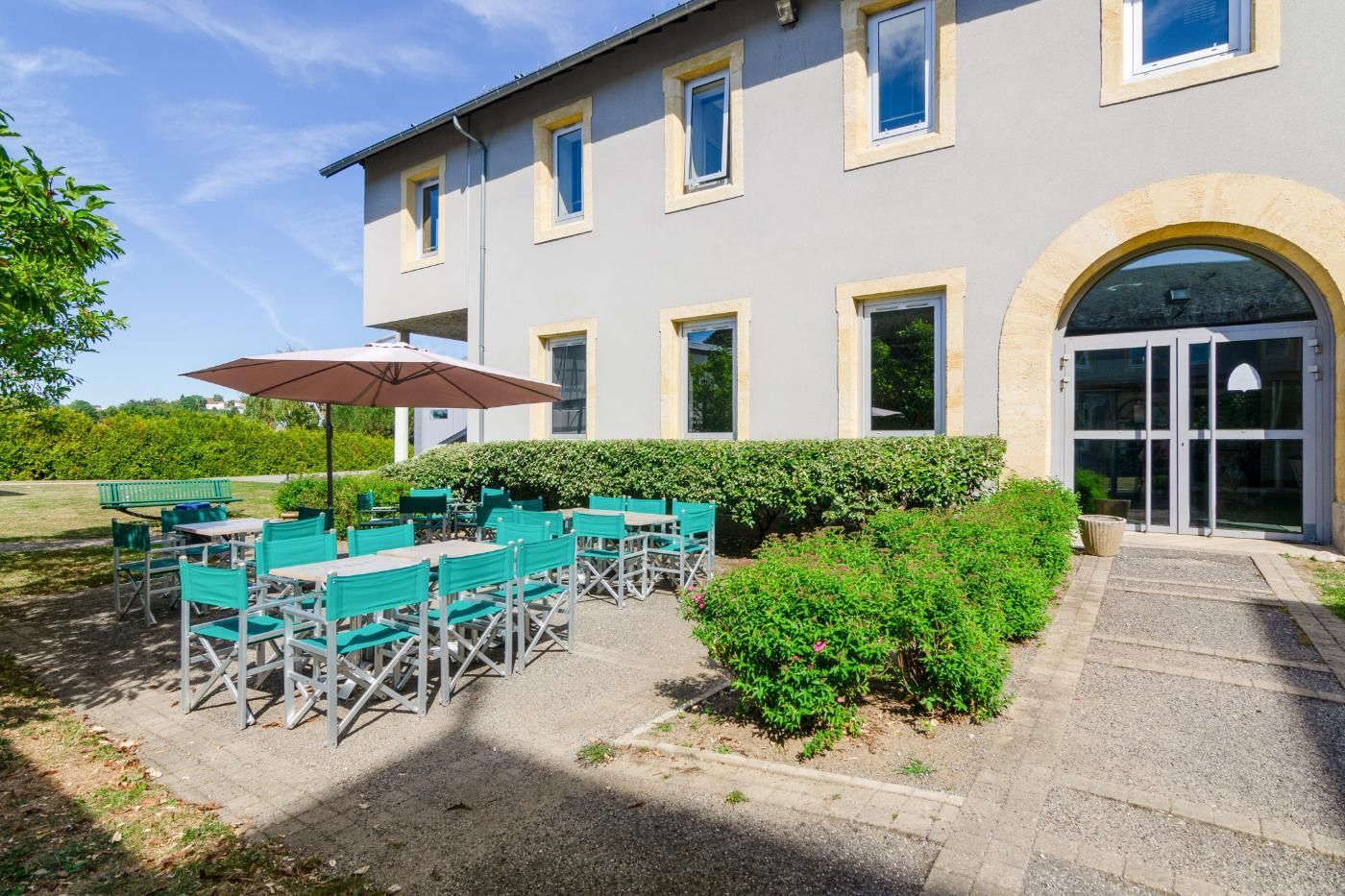 Un patio avec une table et des chaises devant l'un des batiment