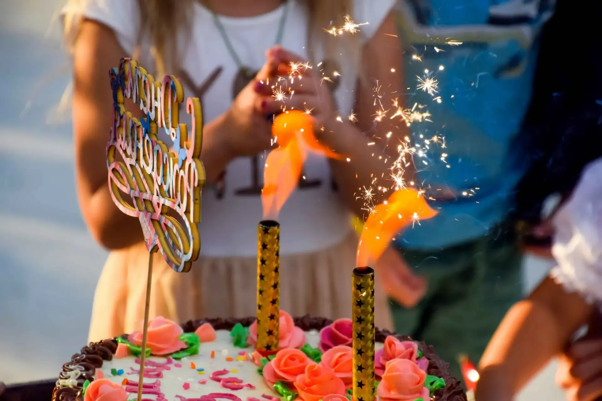 Una niña está encendiendo bengalas en un pastel de cumpleaños.