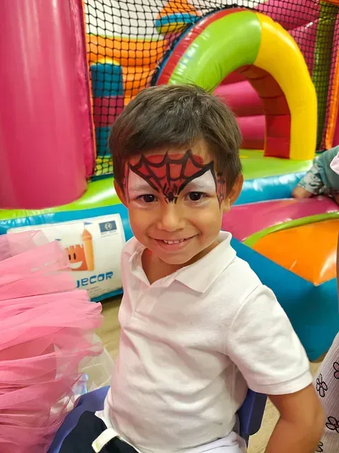 Un niño tiene una cara de Spider-Man pintada en su cara.