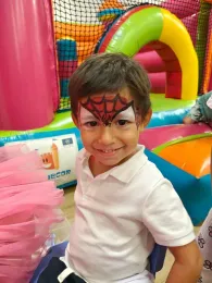 Un niño tiene una cara de Spider-Man pintada en su cara.