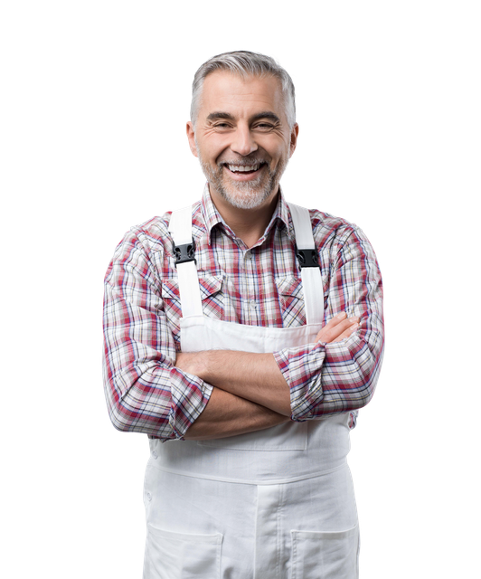 Homme aux cheveux gris et à la barbe, vêtu d'une chemise à carreaux et d'une salopette blanche, les bras croisés, souriant.
