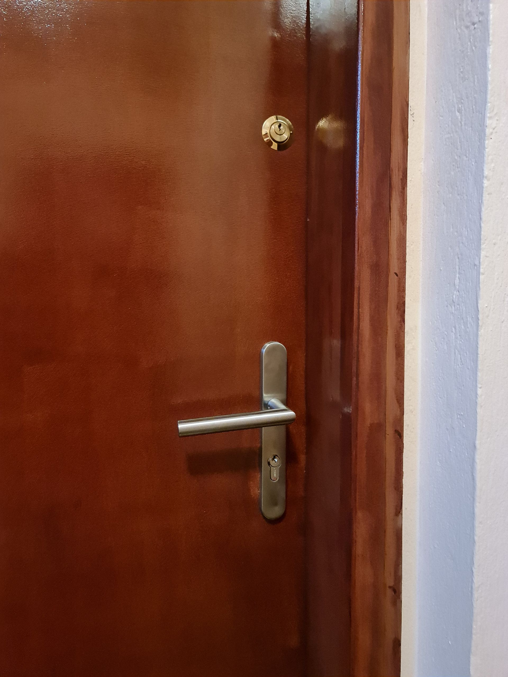 Poignée de porte et homme habillé en rose en fond