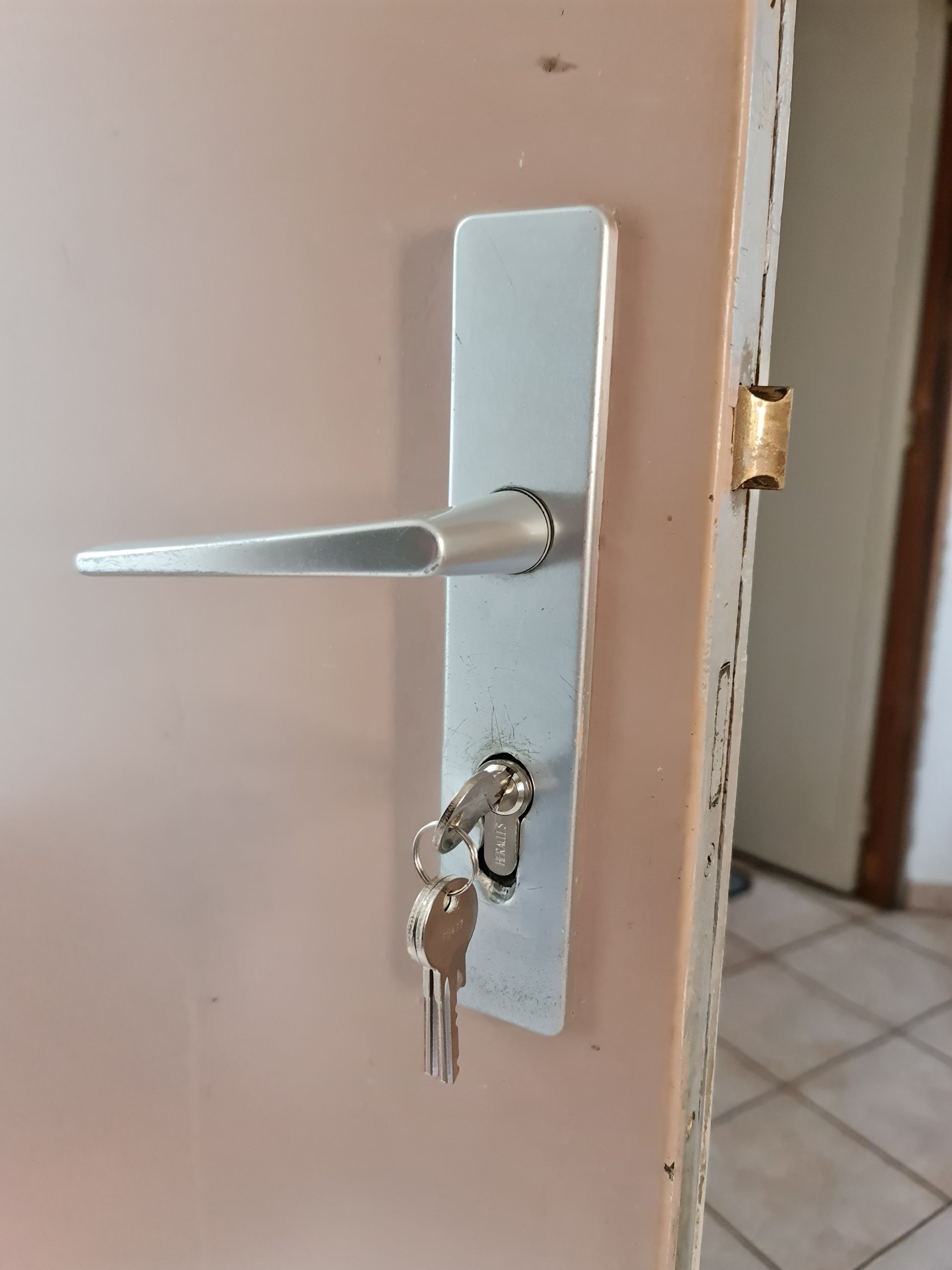 Poignée de porte et homme habillé en rose en fond