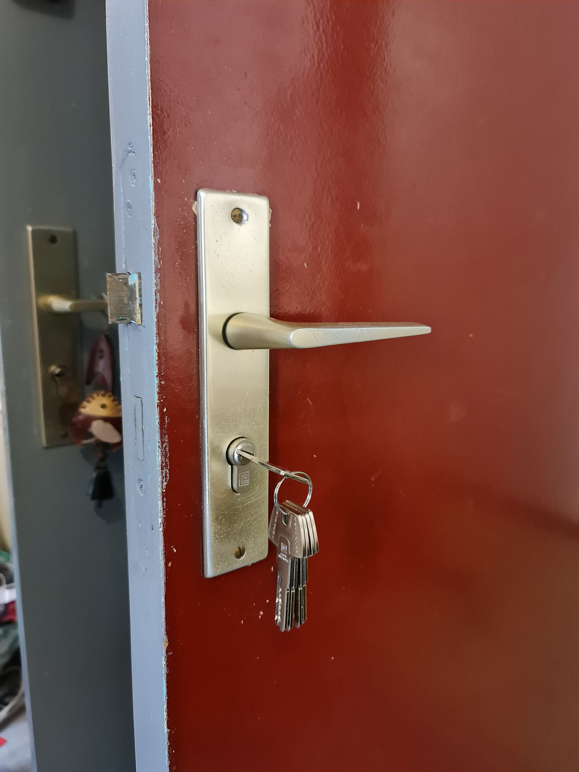 Poignée de porte et homme habillé en rose en fond