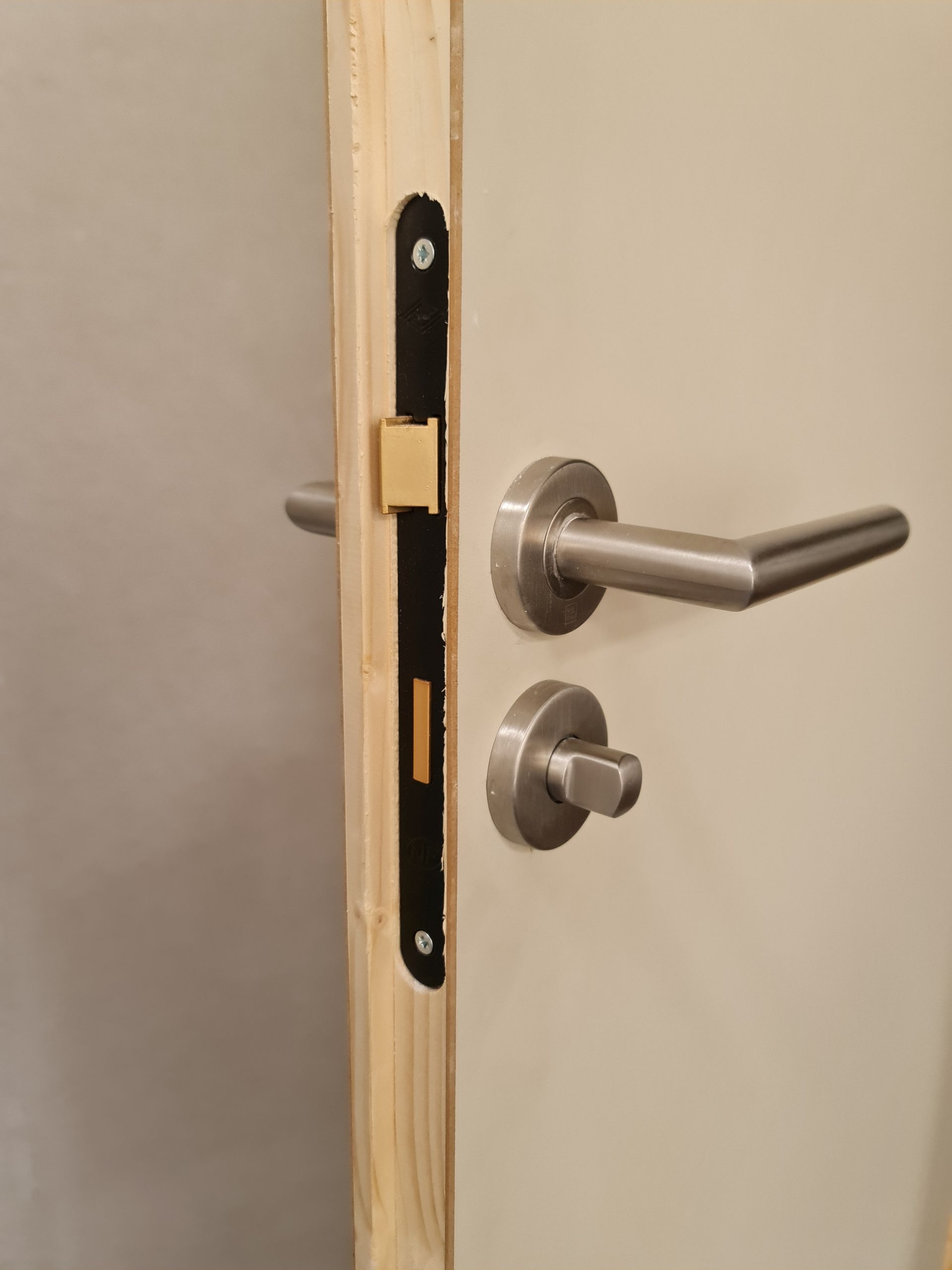 Poignée de porte et homme habillé en rose en fond