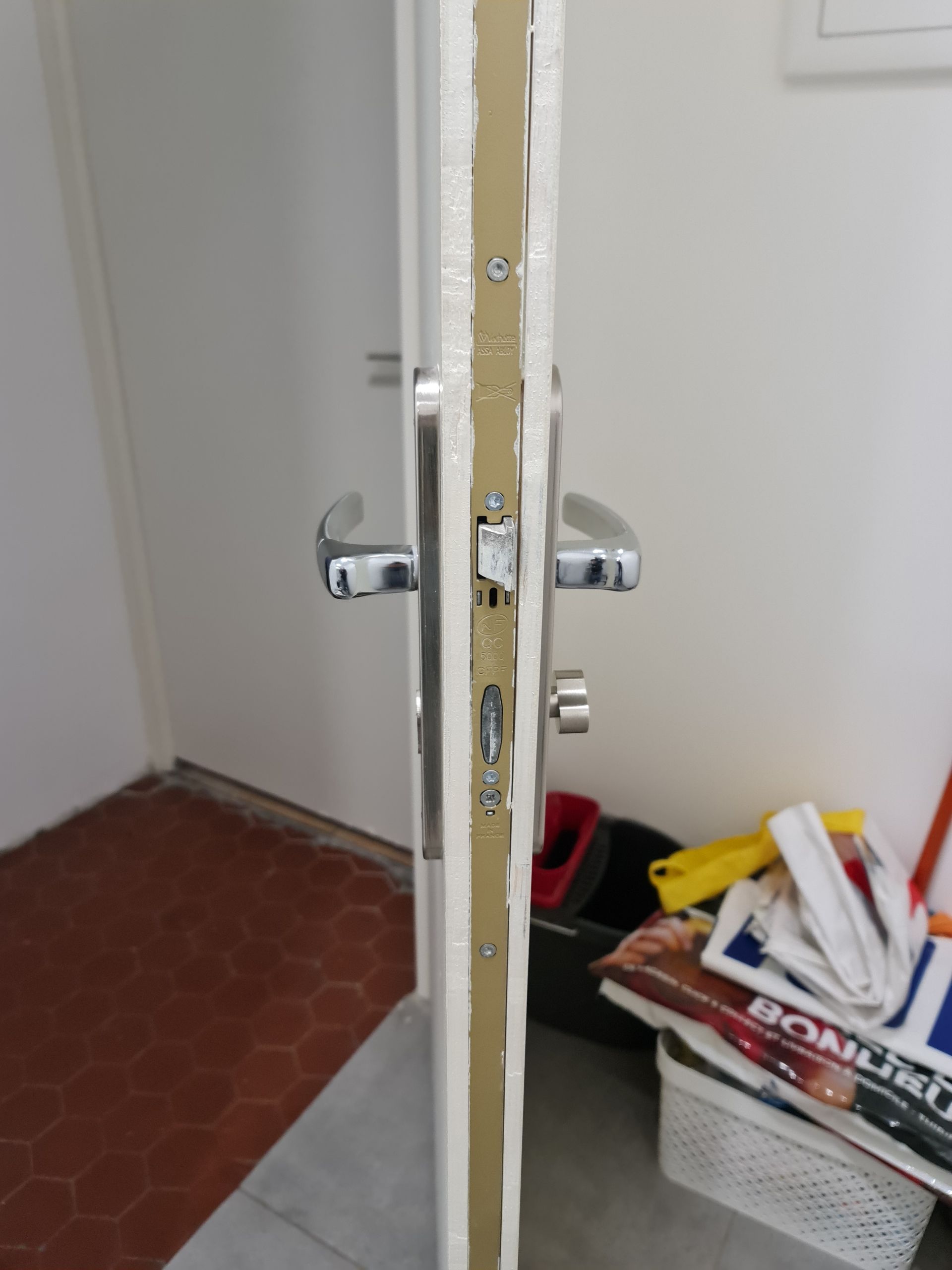 Poignée de porte et homme habillé en rose en fond