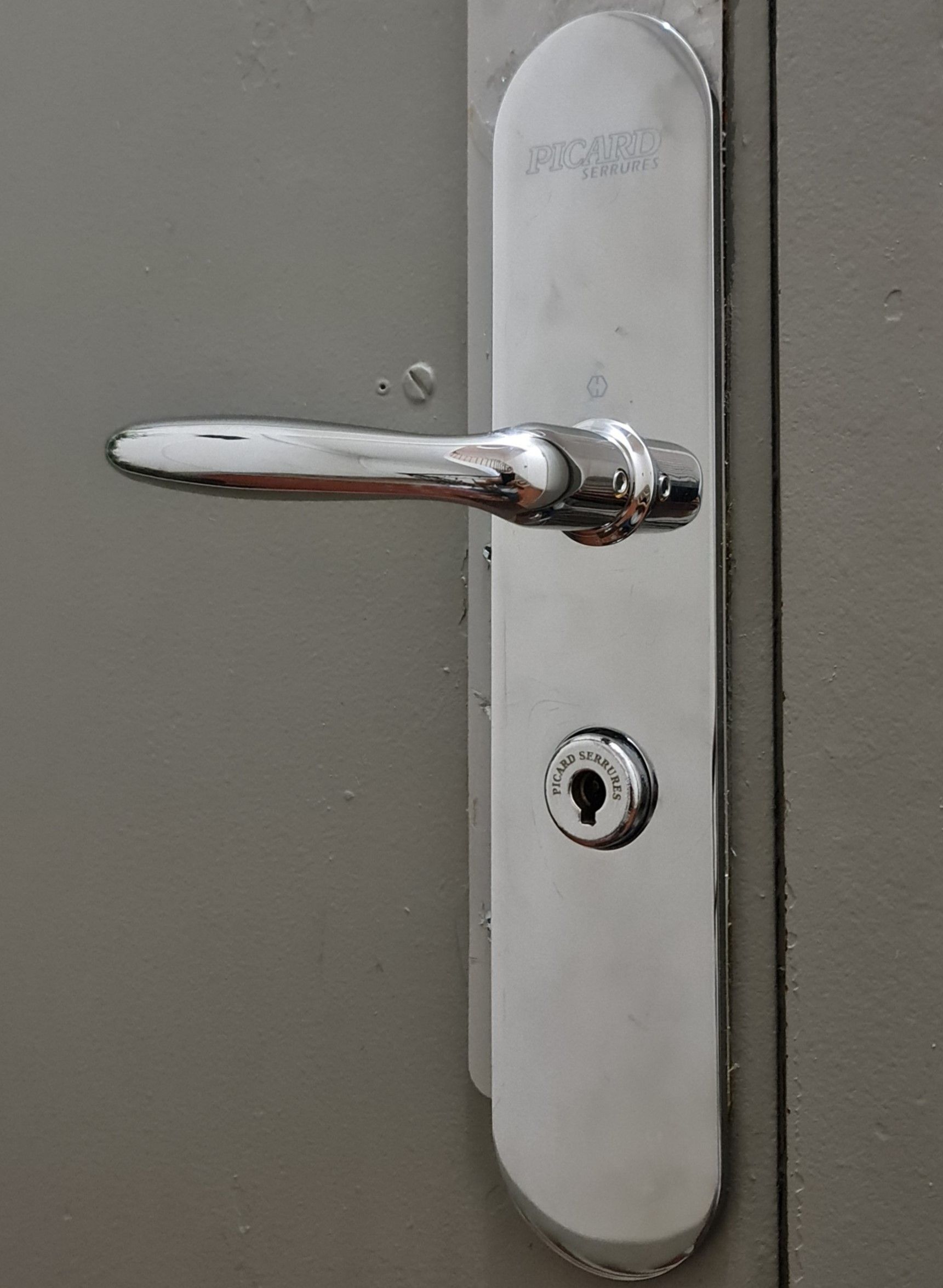 Poignée de porte et homme habillé en rose en fond