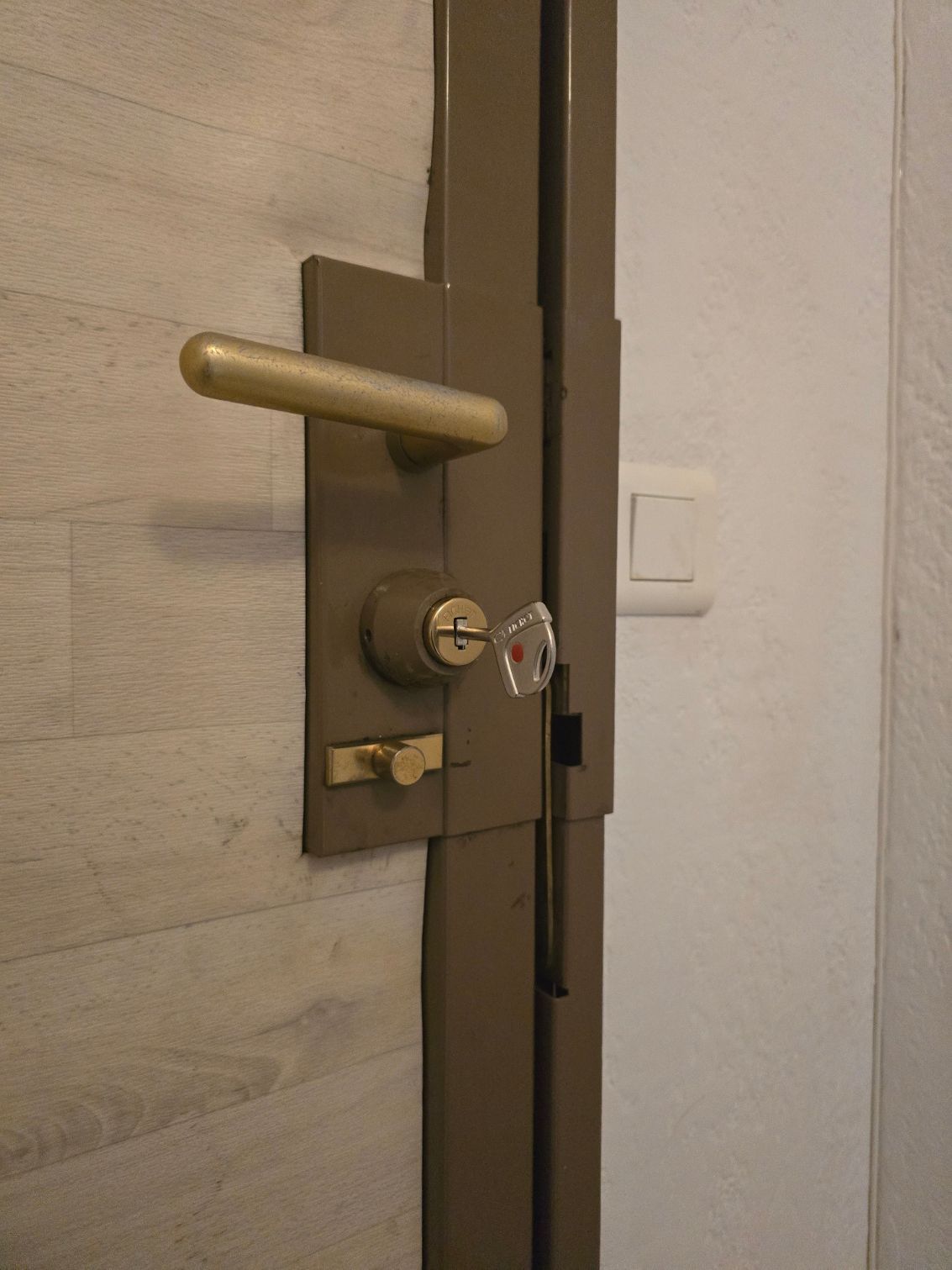 Poignée de porte et homme habillé en rose en fond