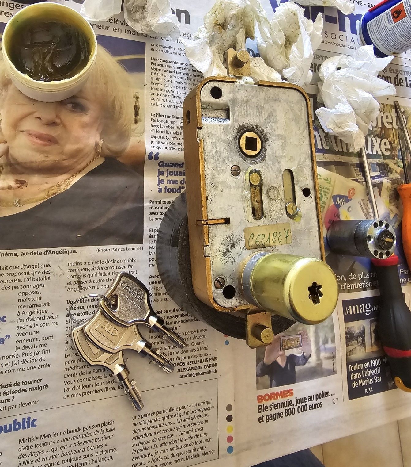 Gros plan sur une poignée de porte argentée avec une serrure rouge sur une porte blanche