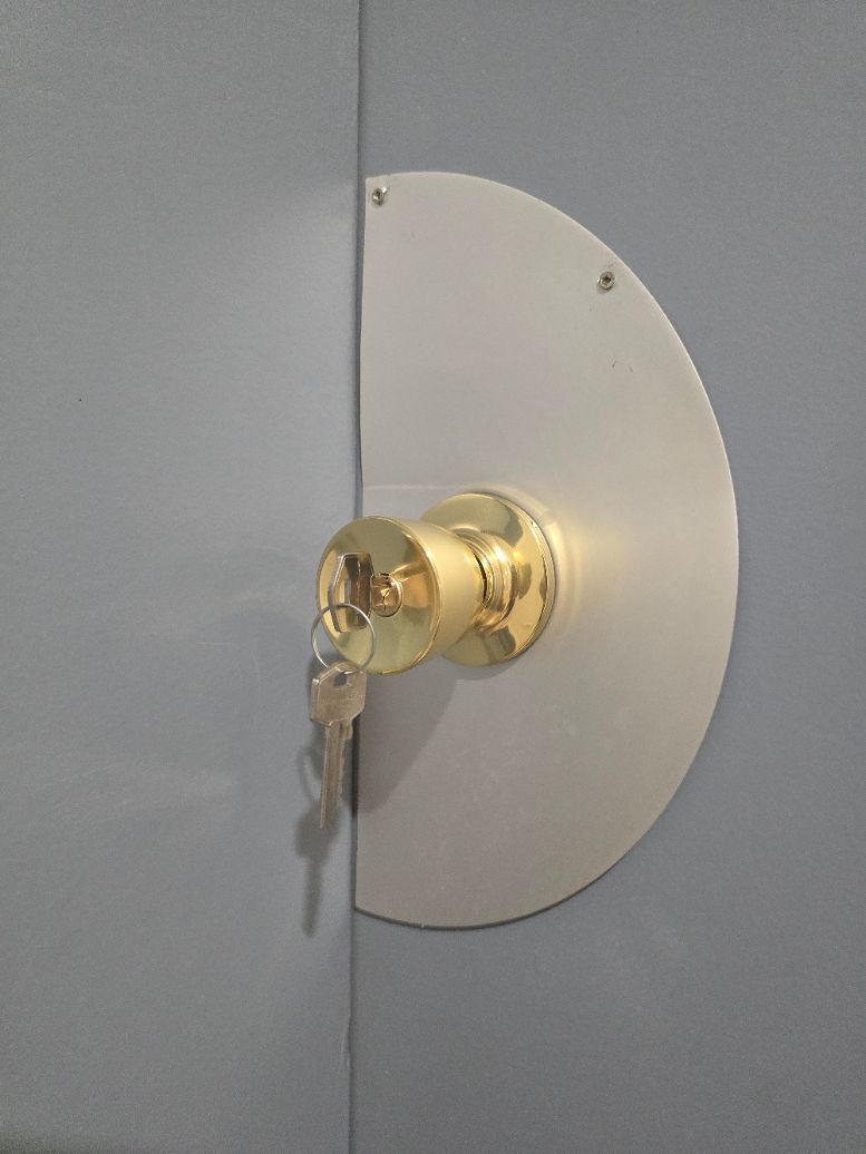 Un serrurier utilise une meuleuse sur une porte en bois, provoquant des étincelles à l'intérieur.
