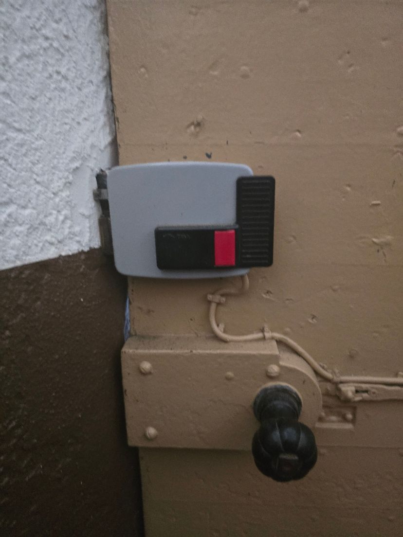 Gros plan d'une porte verte avec loquet métallique, verrou à chaîne et poignée ronde.