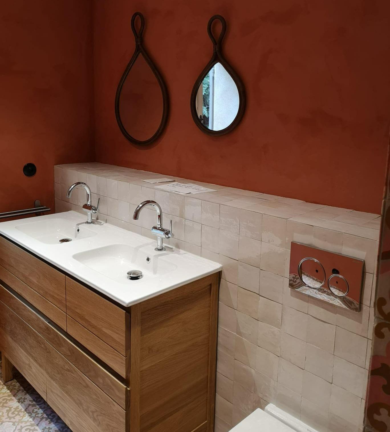 Un coffrage avec des carreaux derrière un meuble sous vasque.