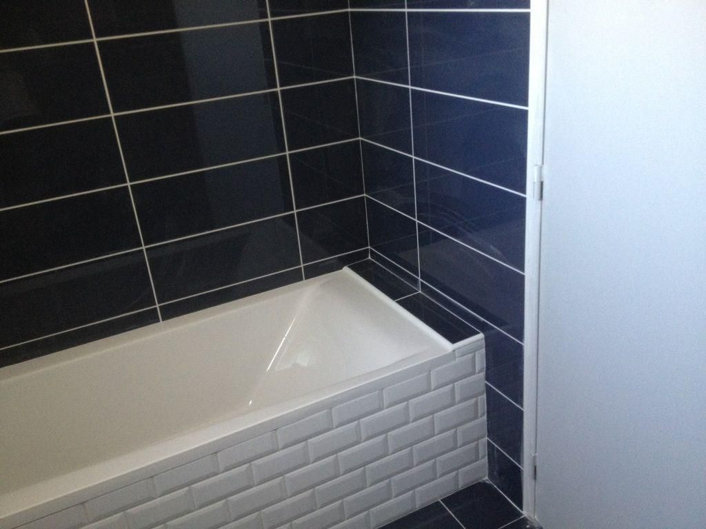 Carrelage bleu et carrelage blanc dans une salle de bains.