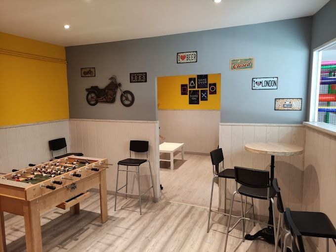 Una habitación con una mesa y sillas y una motocicleta en la pared.