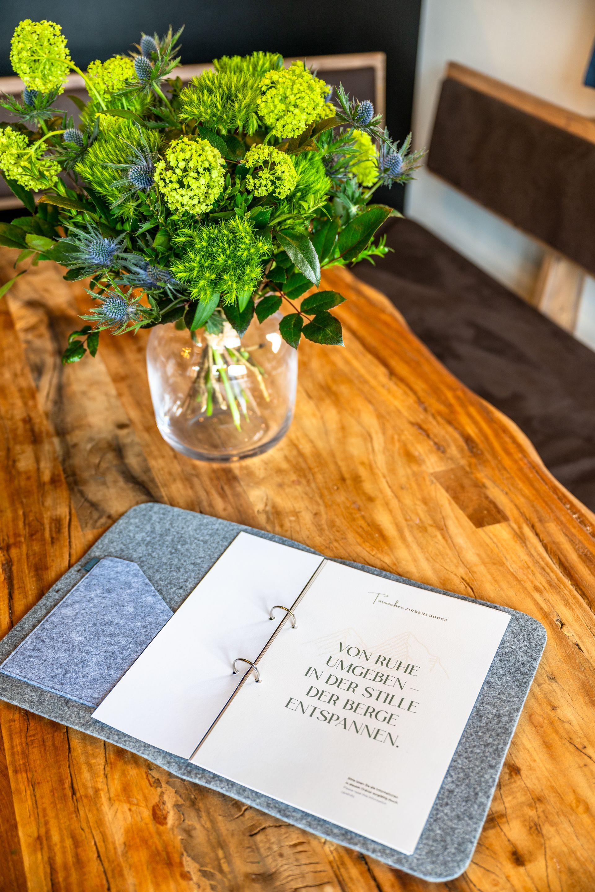 Ein Holztisch mit einem Blumenarrangement