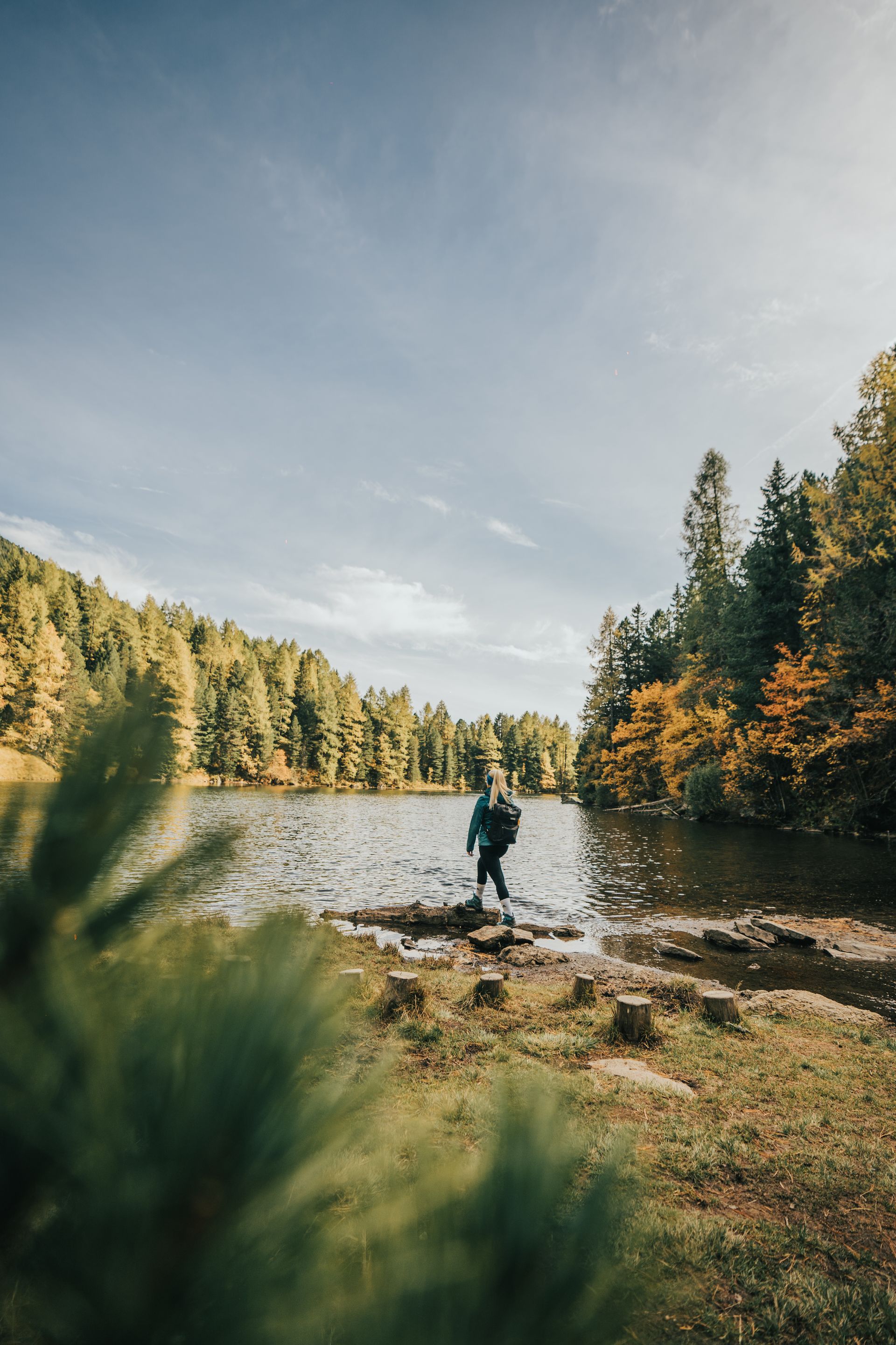 Eine Person steht auf Felsen am Wasserrand