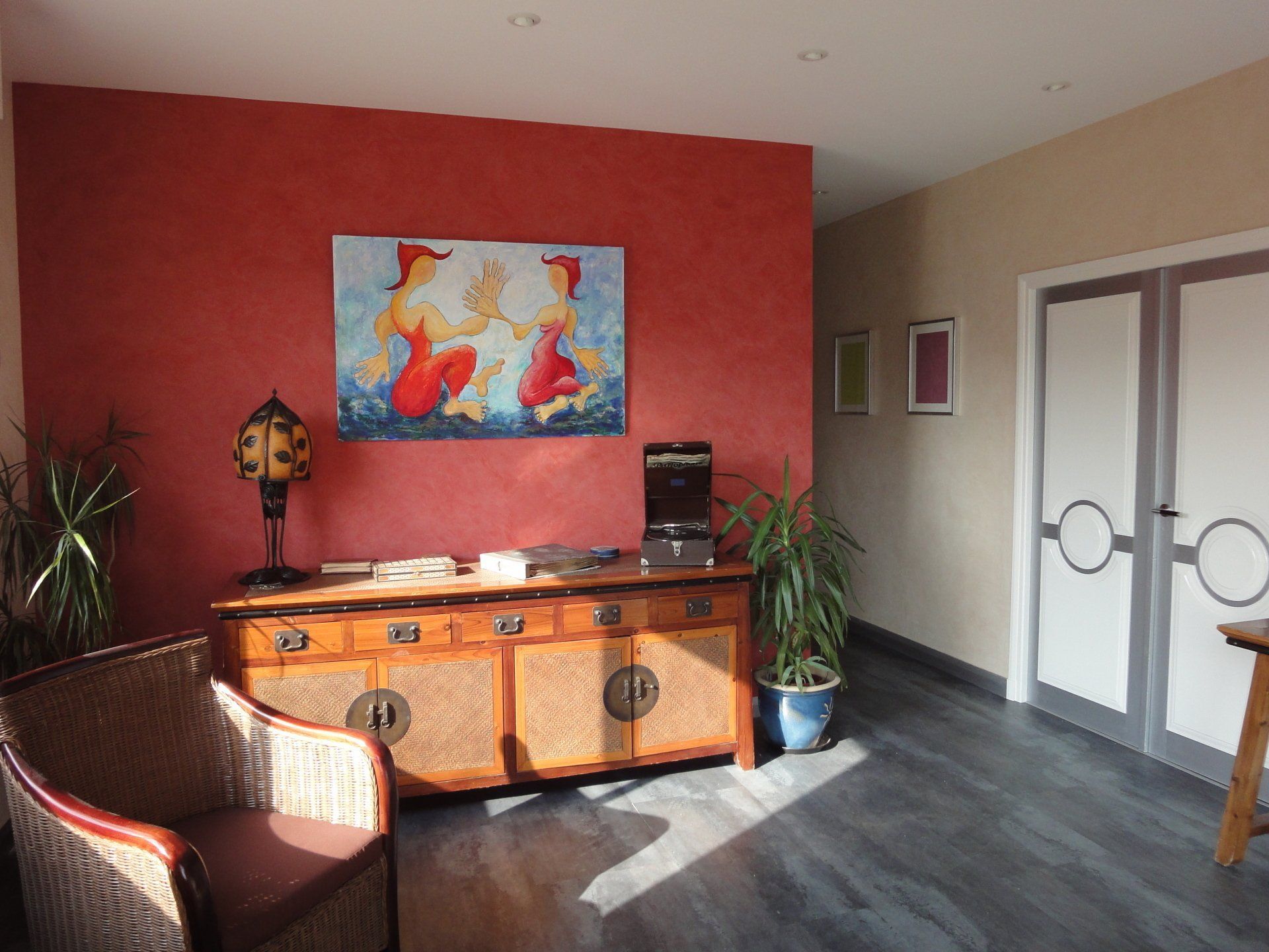 Mur avec papier peint rouge et buffet en bois