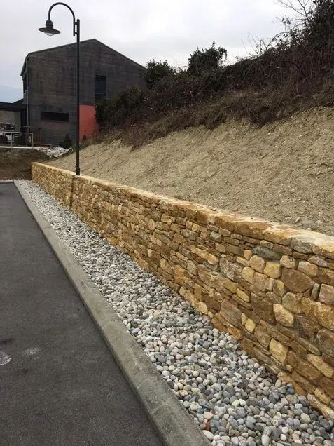 Innenansicht eines großen Gebäudes im Bau. Betonpfeiler, freiliegende Balken und unfertige Fußböden sind sichtbar.