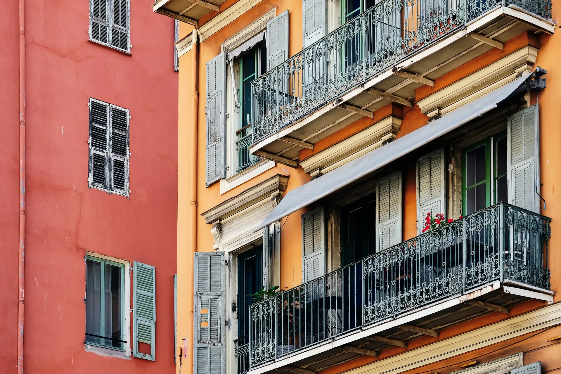 Edificios de apartamentos coloridos con balcones y ventanas ornamentadas en una calle de la ciudad.