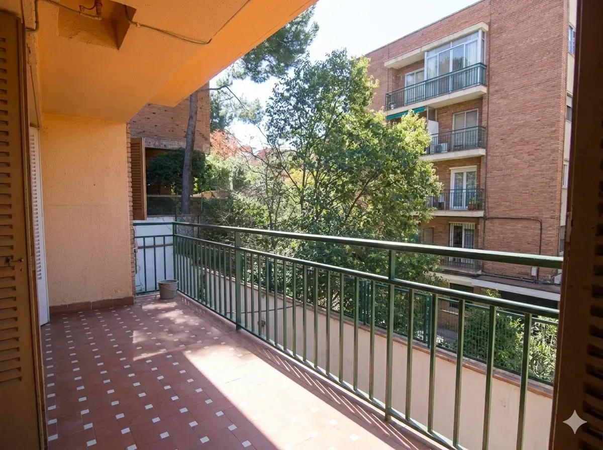 Balcón con barandilla verde con vistas a los árboles y al edificio de apartamentos de ladrillo.