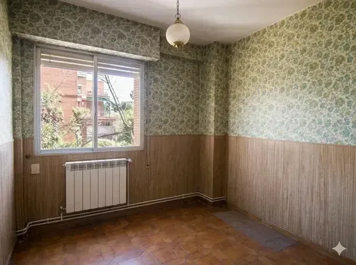 Habitación vacía con paredes revestidas de madera, papel pintado estampado, ventana, radiador y lámpara colgante.