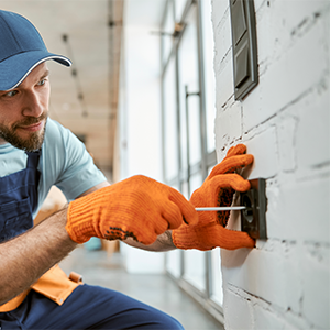 Électricien travaillant sur une prise murale