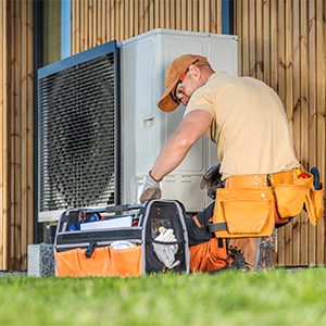 Technicien en tenue orange réparant un climatiseur