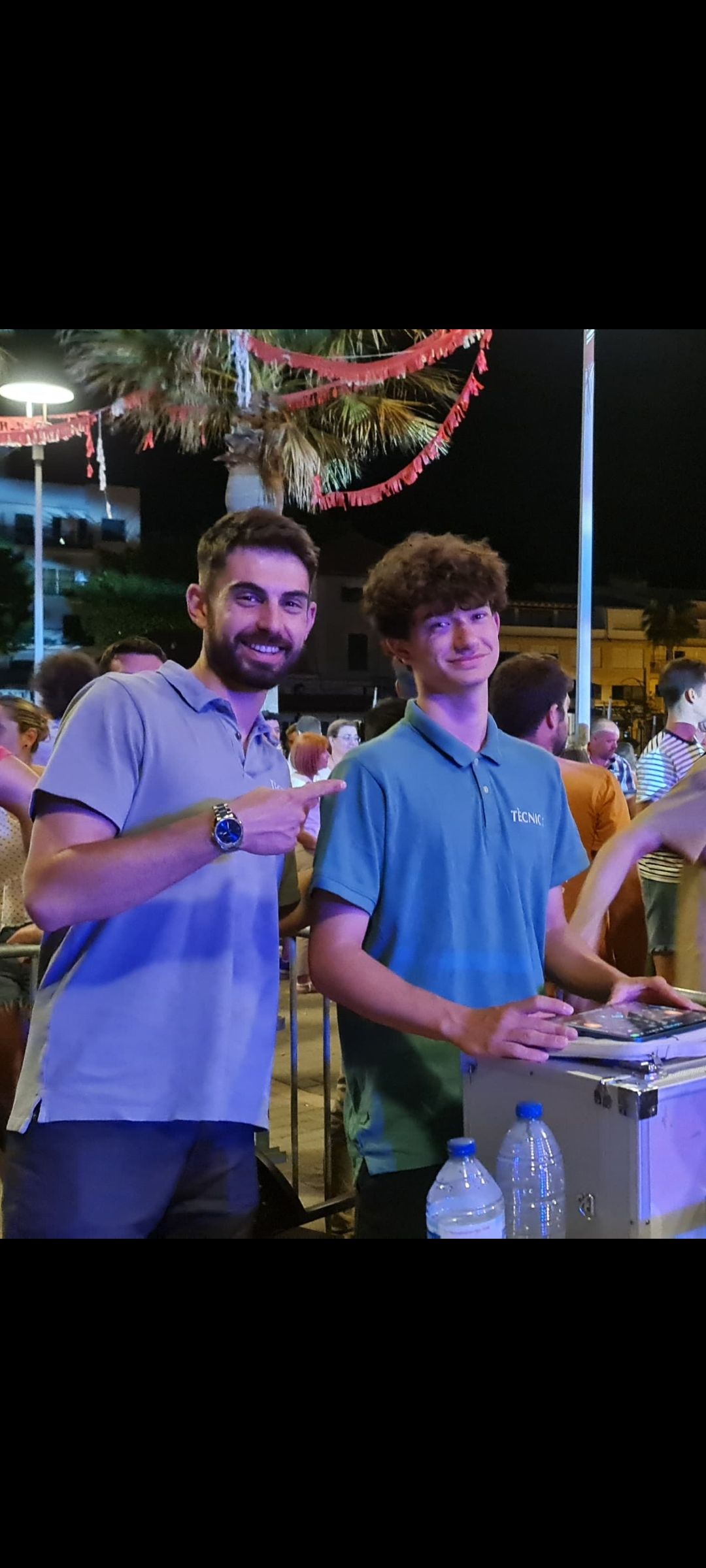 Dos hombres están parados uno al lado del otro en una multitud.