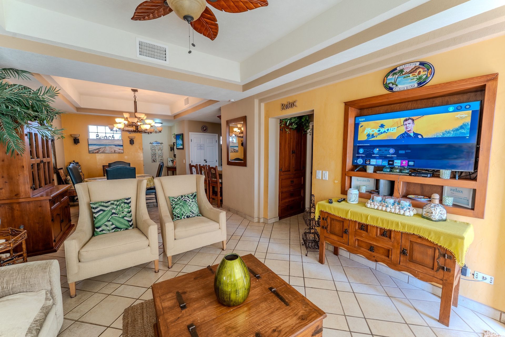 Patio overlooking a beach with seating, grill, and ocean view on a sunny day.