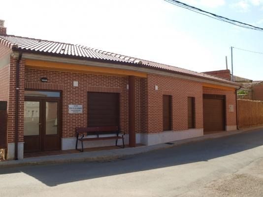 Un edificio de ladrillo con un banco delante.