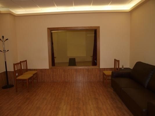 Una sala de estar con un sofá y sillas y una ventana grande.