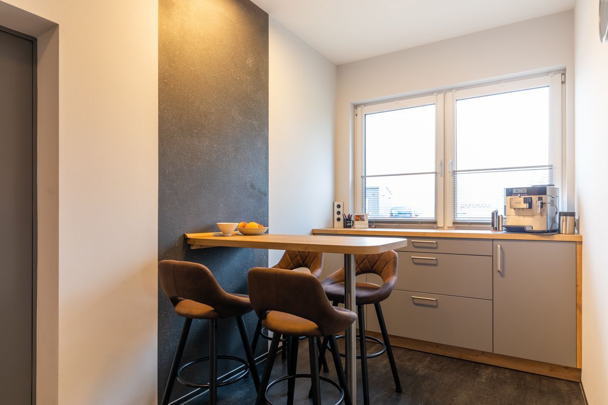 Eine Küche mit Tisch und Stühlen und einem Fenster.