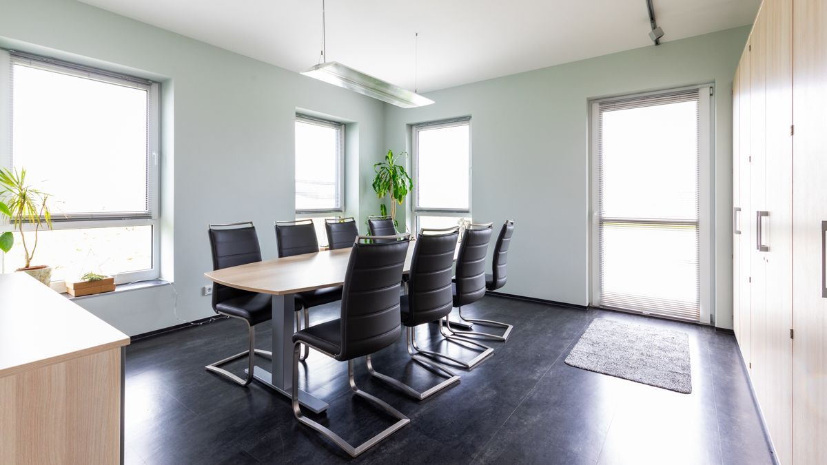 Ein Konferenzraum mit einem langen Tisch und Stühlen.