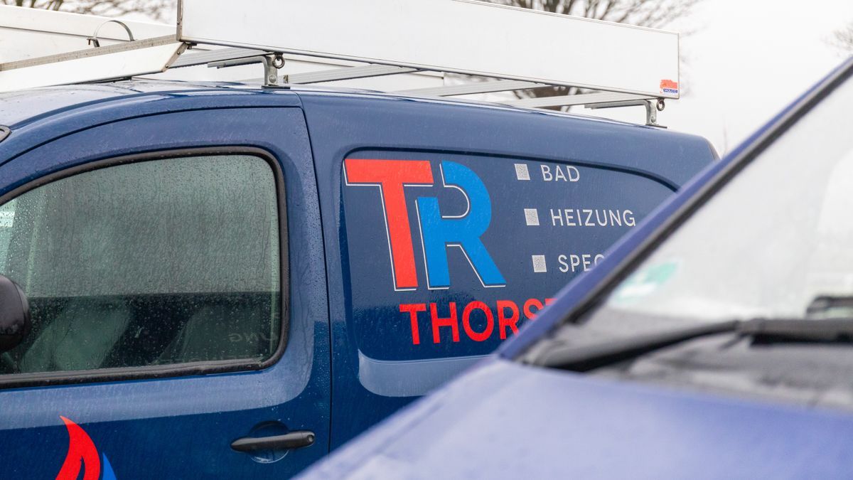 Ein blauer Lieferwagen mit dem Wort „Thor“ auf der Seite ist neben einem anderen Lieferwagen geparkt.