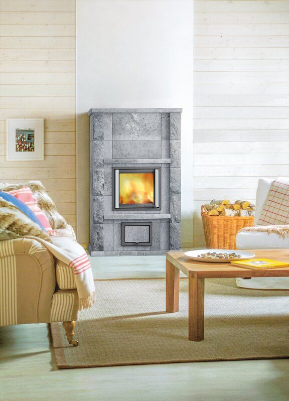 Ein Wohnzimmer mit Kamin, Couch, Tisch und Stühlen.