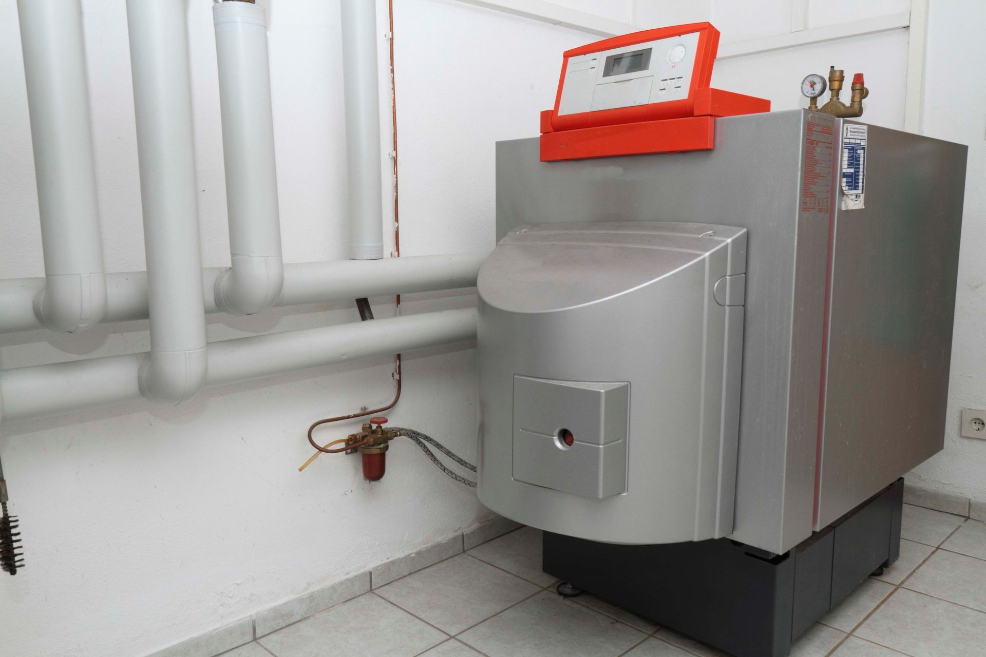 Ein großer Heizkessel steht in einem Raum neben einer Wand.