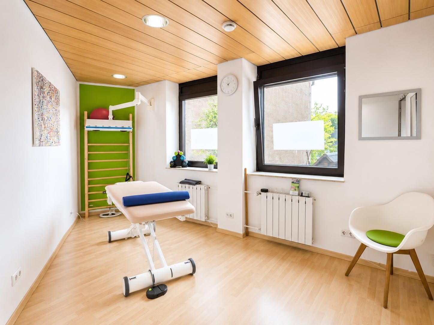 Modernes Behandlungszimmer mit Liege und Sprossenwand