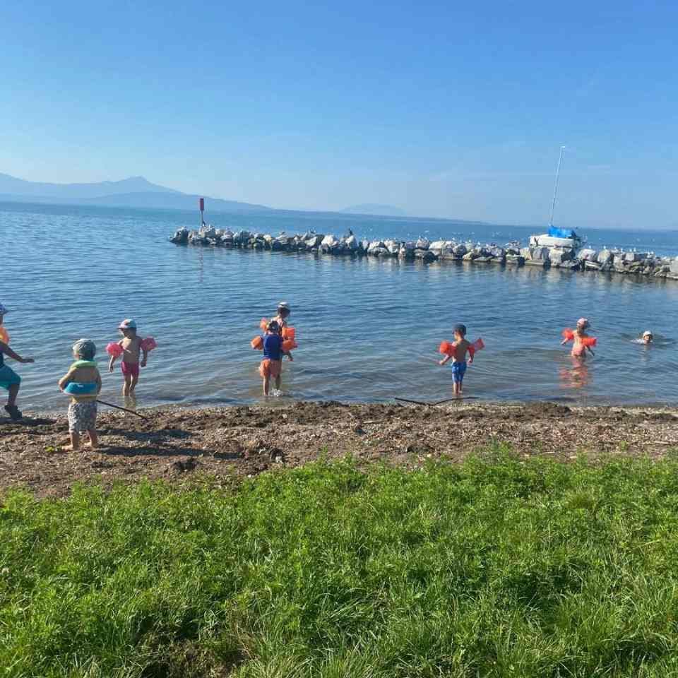 Un groupe d'enfants jouent dans l'eau sur une plage.