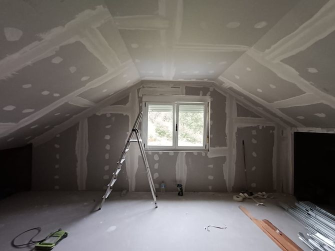 Una habitación vacía con una escalera y una ventana.