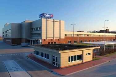 Eine Luftaufnahme eines großen Gebäudes mit einem kleinen Gebäude davor.