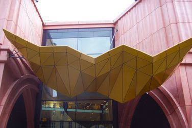 Ein Gebäude mit einer gelben Skulptur darauf