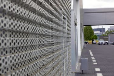 Eine Nahaufnahme einer Metallwand mit Löchern darin.