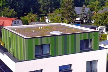 Eine Luftaufnahme eines grün-weißen Gebäudes mit einem grünen Dach.