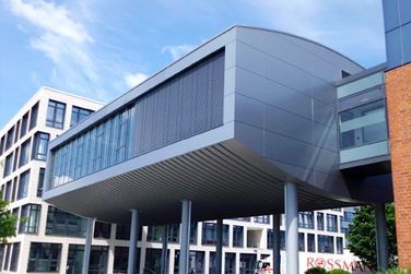 Ein großes Gebäude mit vielen Fenstern ist von anderen Gebäuden umgeben.