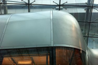 Ein Gebäude mit geschwungenem Dach und vielen Fenstern.