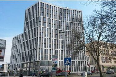 Ein großes Gebäude mit vielen Fenstern und einem Schild mit der Aufschrift „a“ darauf