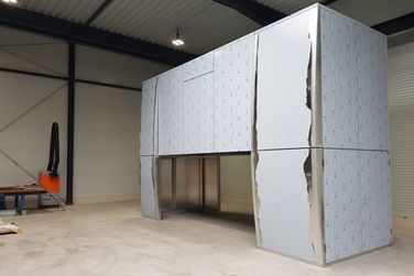 In einem Lagerhaus steht eine große Konstruktion aus rostfreiem Stahl.