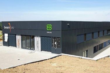 Ein großes schwarzes Gebäude mit einem grünen Logo an der Seite.