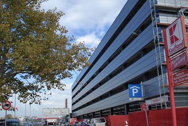 Ein großes Gebäude mit einem Parkschild davor