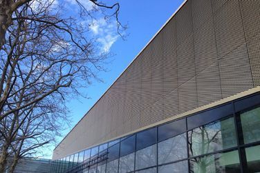 Ein großes Gebäude mit vielen Fenstern und einem Baum davor.